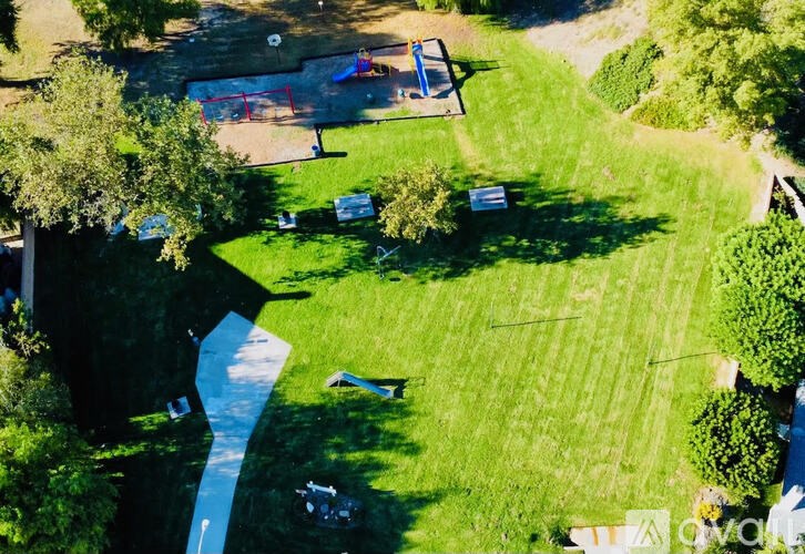 A park with a blue pathway and a playground.