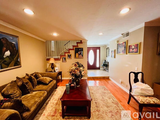 A living room with a brown leather couch and a wooden coffee table.