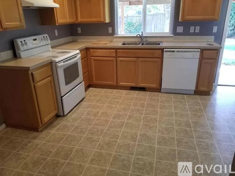 A kitchen with wooden cabinets and a white stove top oven.