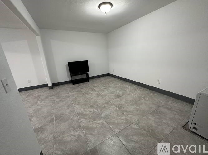 A room with a tiled floor and a television set.