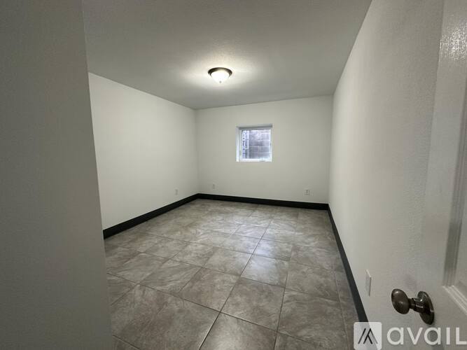 A room with tiled flooring and a window.