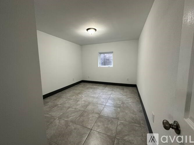 A room with tiled flooring and a window.