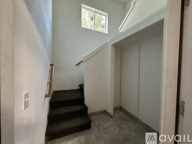 A staircase with a carpeted runner leads up to a window.
