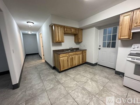 A kitchen with wooden cabinets and a white stove top oven.
