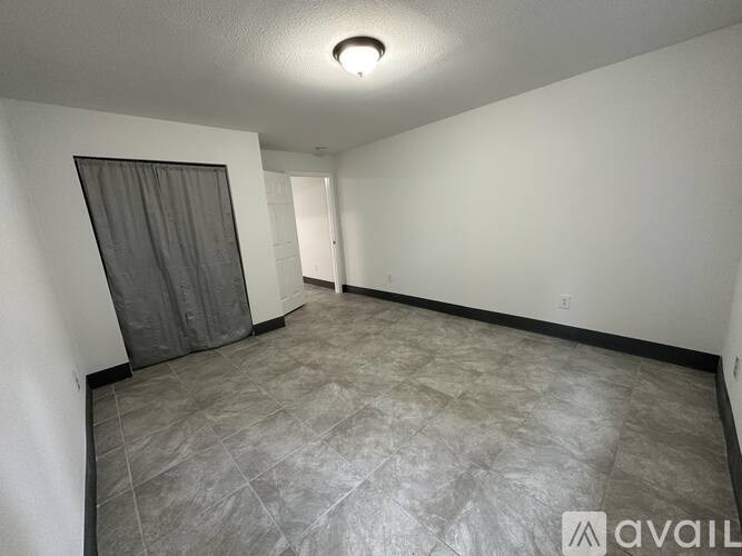 A room with a grey floor and a grey curtain.