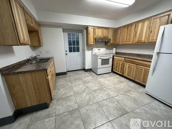 A kitchen with wooden cabinets and white appliances.