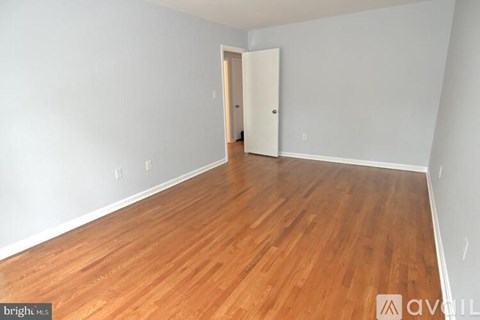 A room with wooden flooring and a white door.
