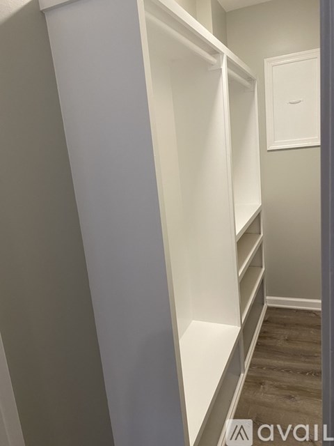 A white closet with shelves and a door.