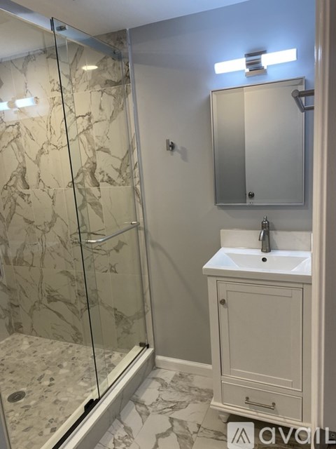 A bathroom with a marble floor and a white sink.