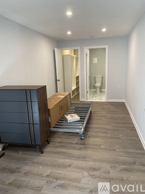 A room with a wooden cabinet and a trolley with boxes on it.