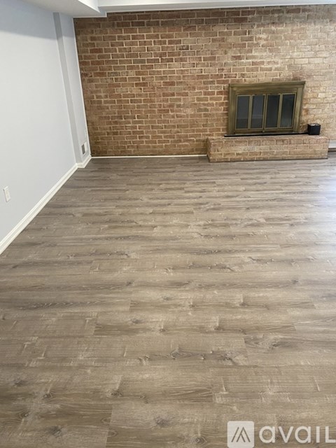 A room with a brick wall and wooden flooring.