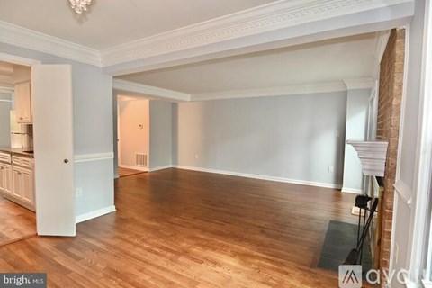 A spacious room with wooden floors and white walls.