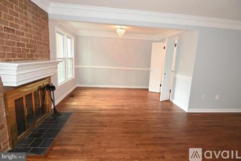 A room with a fireplace and wood flooring.
