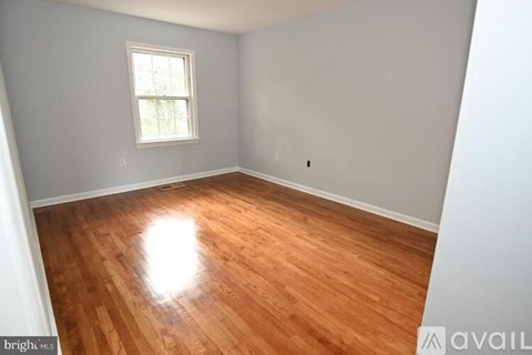 A room with wooden flooring and a window.
