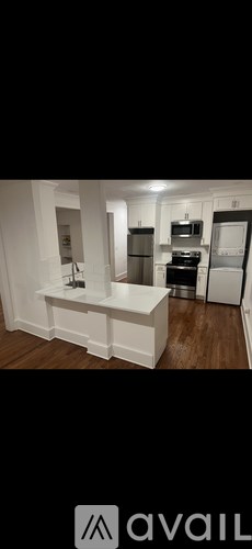 A kitchen with white cabinets and a wooden floor.