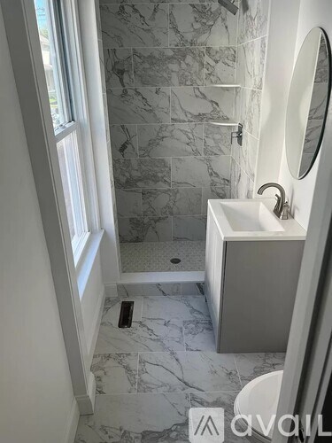 A bathroom with a marble floor and a white sink.