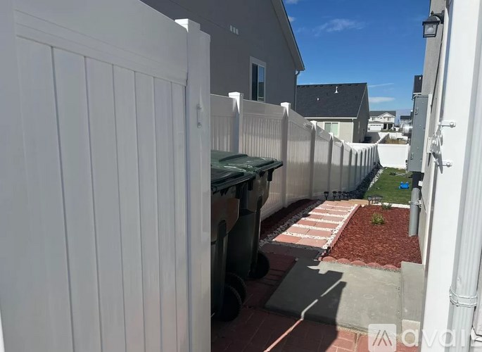 A white fence with a small garden in front of it.