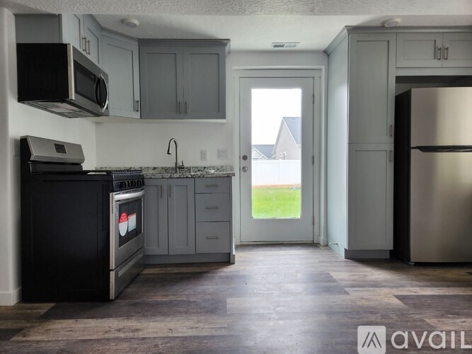 A kitchen with a black oven and a black microwave above it.