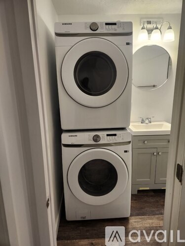 Two Samsung front loading washing machines in a small laundry room.