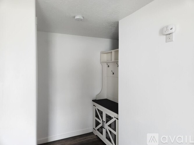 A white cabinet with a black countertop is in a room with white walls.