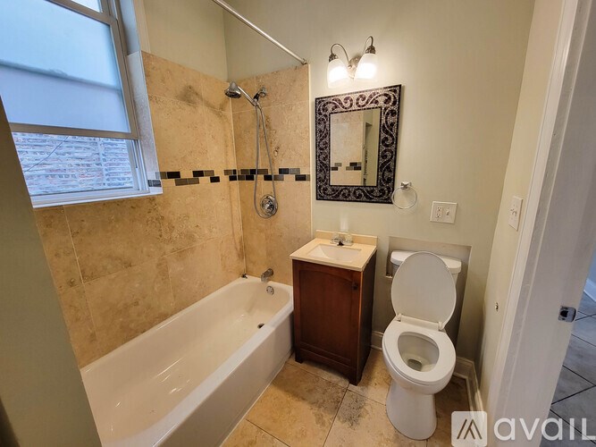 A bathroom with a tub, toilet, and sink.
