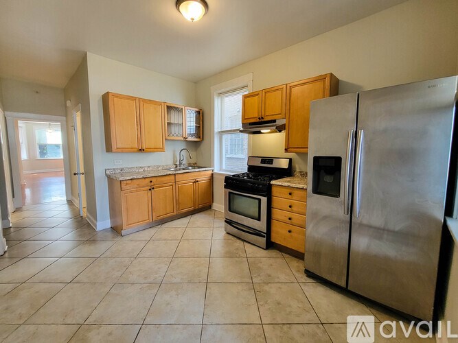 A kitchen with a refrigerator, oven, microwave, and sink.