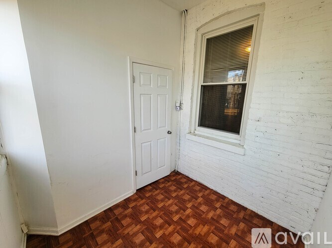 A room with a white door and a window with blinds.
