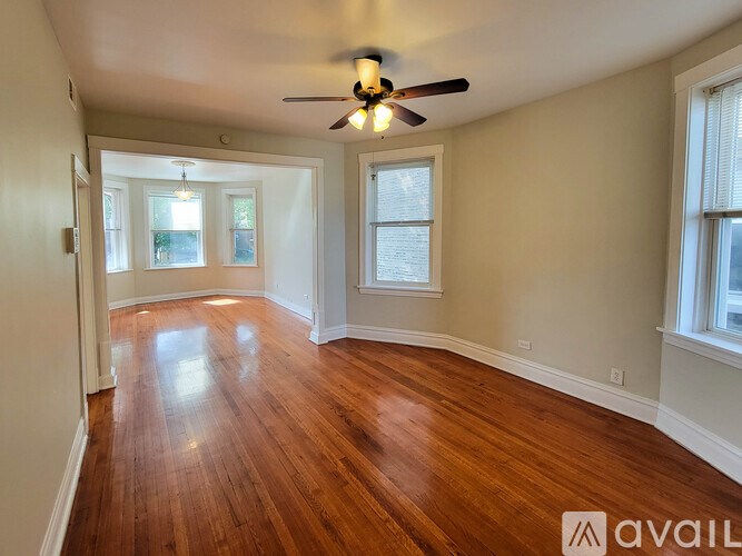 A room with wooden floors and a ceiling fan.