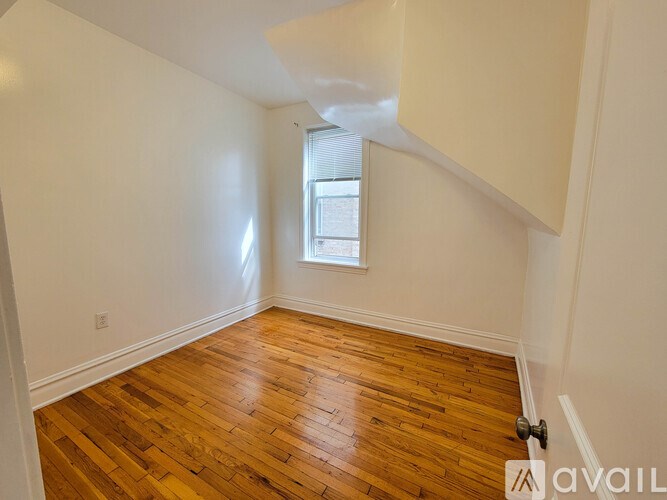 A room with wooden flooring and a window.
