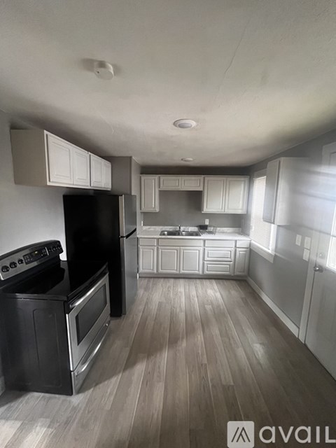A modern kitchen with black appliances and white cabinets.