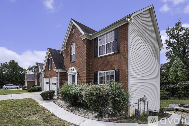 A house with a red brick exterior and a white garage door.