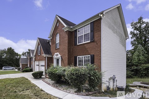 A house with a red brick exterior and a white garage door.