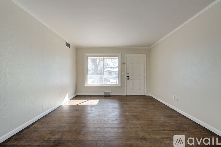 A room with wooden floors and a white door.