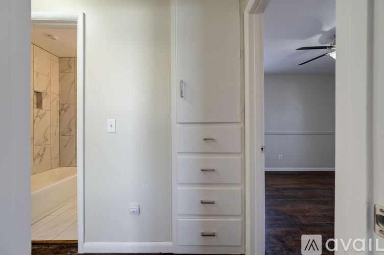 A bathroom with a marble tub and white walls.