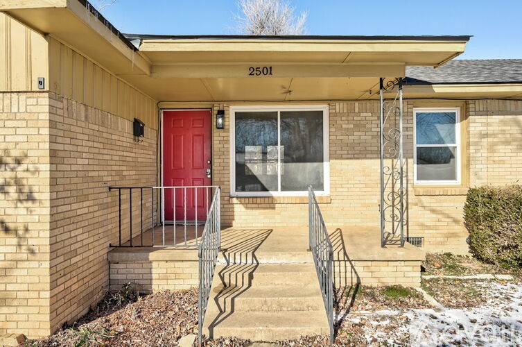 A house with a red door and a black railing.