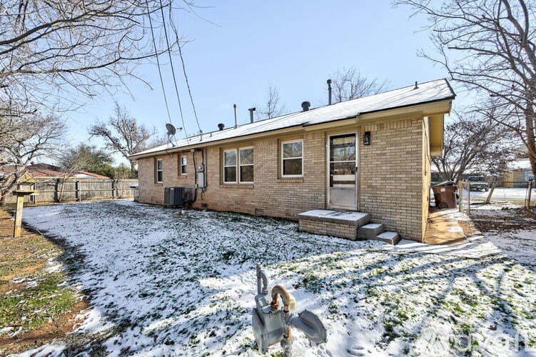 A house with a person shoveling snow in front.