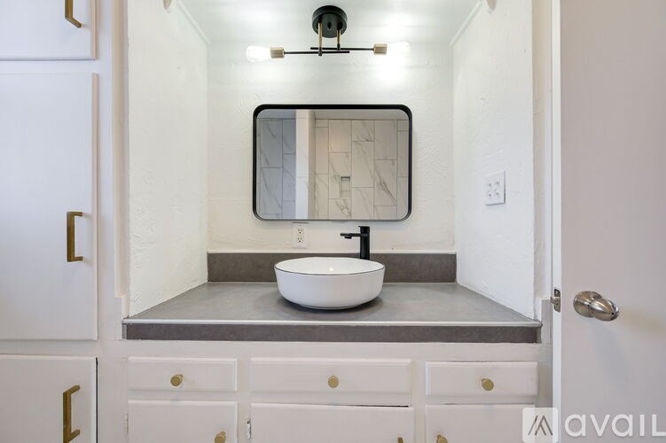 A bathroom with a white sink and a mirror above it.