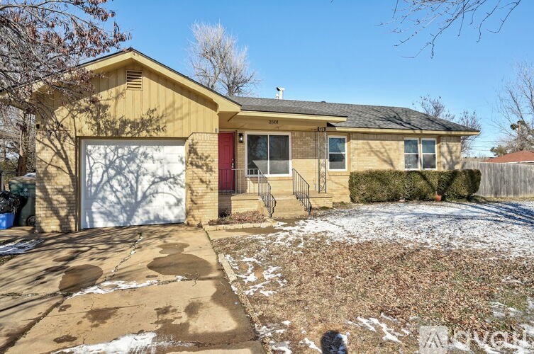 A house with a red door and a garage door.
