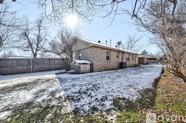 A house with a snow-covered ground in front of it.