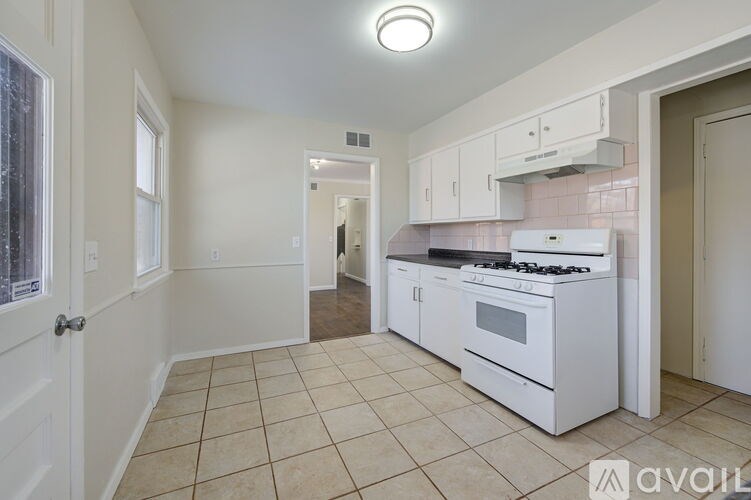 A kitchen with white appliances and cabinets.