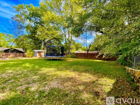 A backyard with a swing set and a fence.