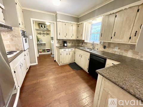 A kitchen with wooden floors and cabinets.