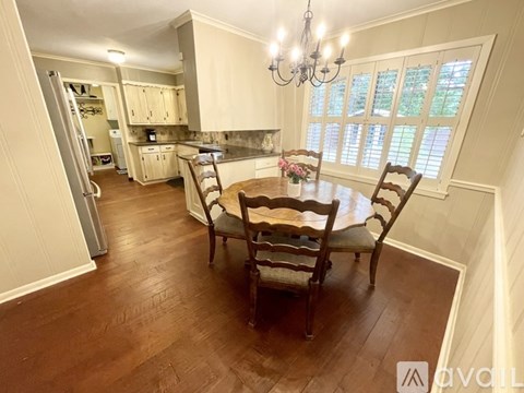 A kitchen with a dining table and chairs.