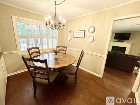 A dining room with a wooden table and chairs.