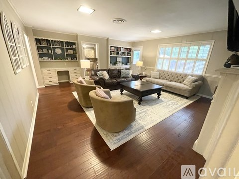 A living room with a couch, chairs, and a coffee table.