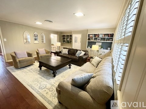 A living room with a couch, chairs, and a coffee table.