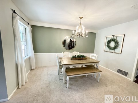 A dining room with a wooden table and chairs.