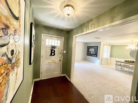 A hallway with a painting of a dog on the wall and a door with the letter B on it.