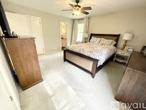 A bedroom with a large bed and a wooden dresser.