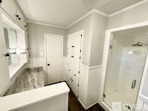 A white bathroom with a walk in shower.